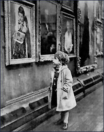 The artist's grandson, Graham, looking at his grandfather's portrait of him at The Royal Society of Portrait Painters' exhibition, 1958